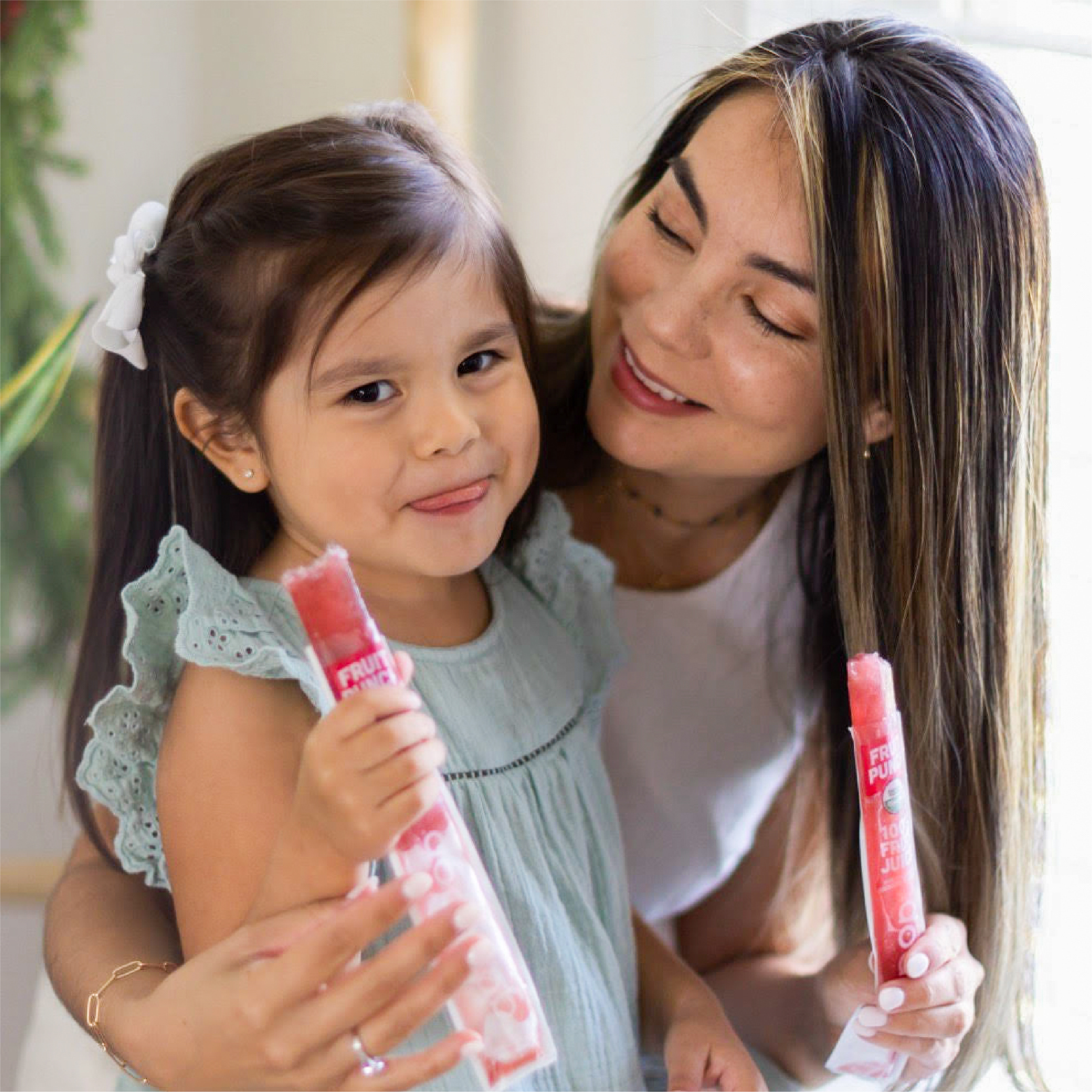 Mother and young daughter smile as they each enjoy an Organic Freezer Pop from GoodPop