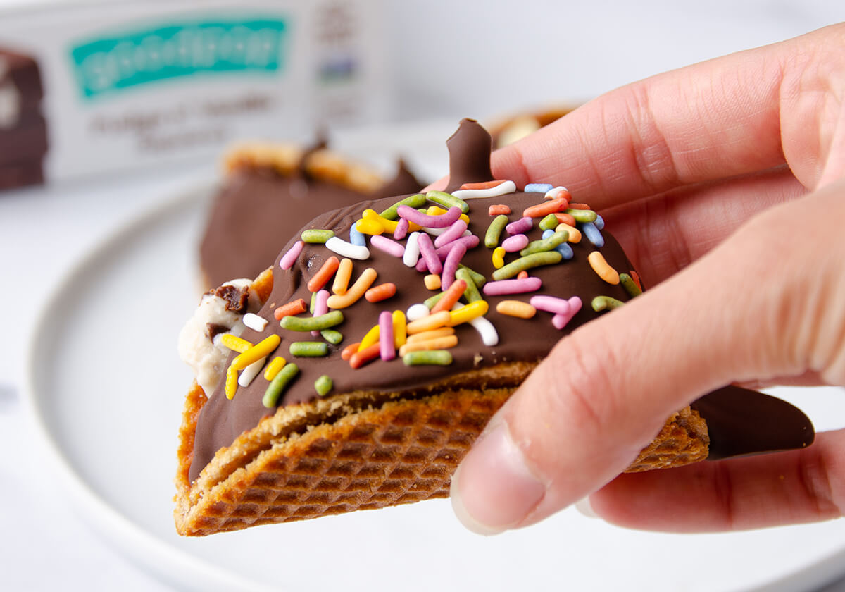 Hand holding a Mini Choco Taco with sprinkles on it