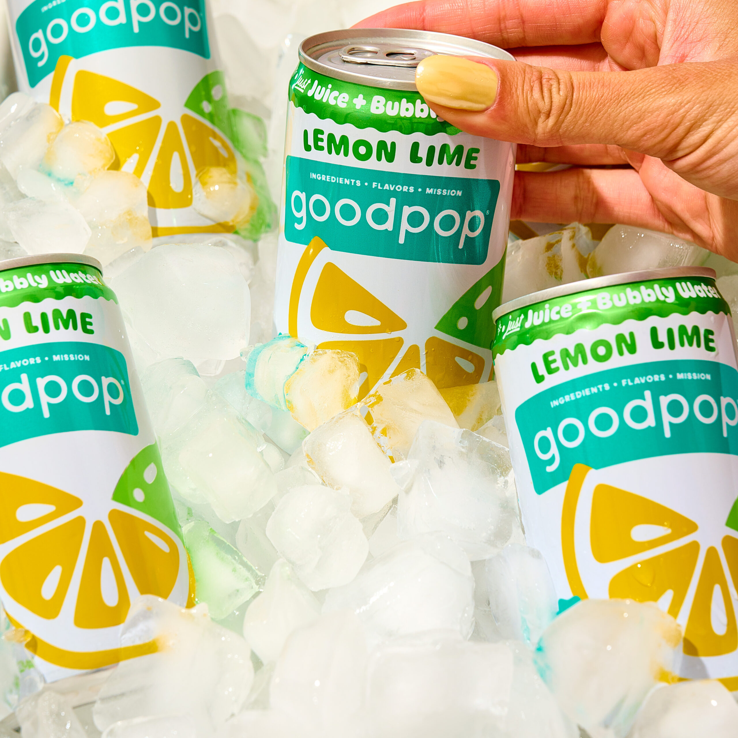 Woman grabs a GoodPop Lemon Lime Mini Can out of a cooler full of ice