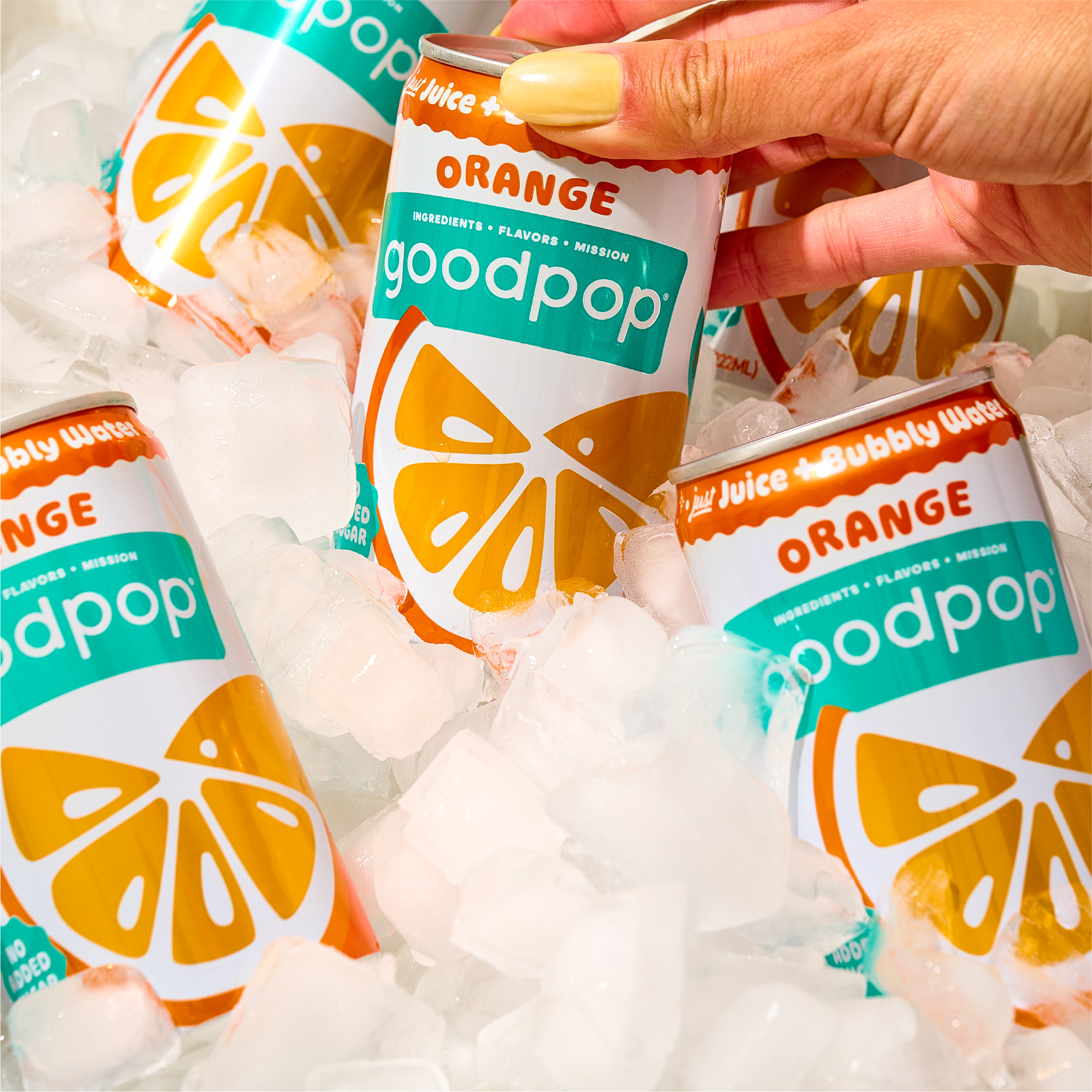 Woman grabs a GoodPop Orange Mini Can out of a cooler full of ice