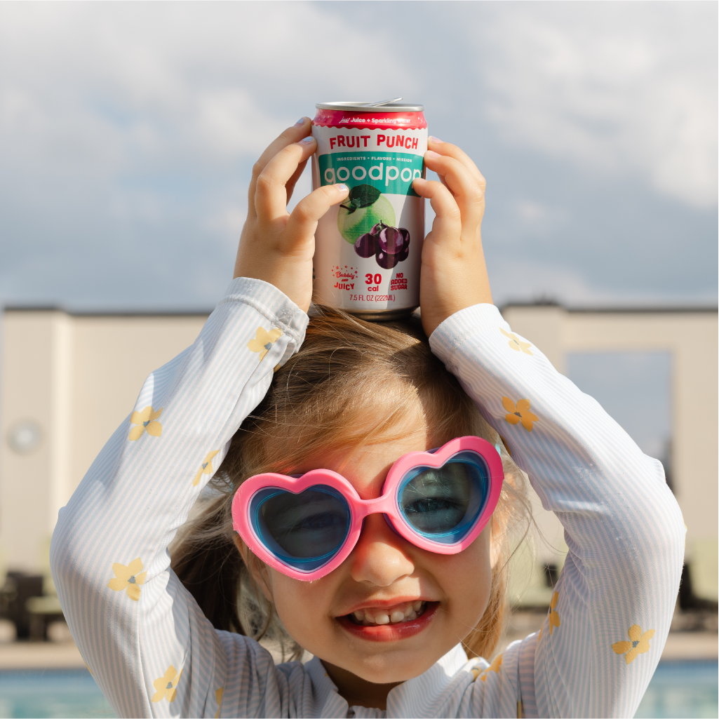 Girl in heart sunglasses holding GoodPop Fruit Punch Mini Can