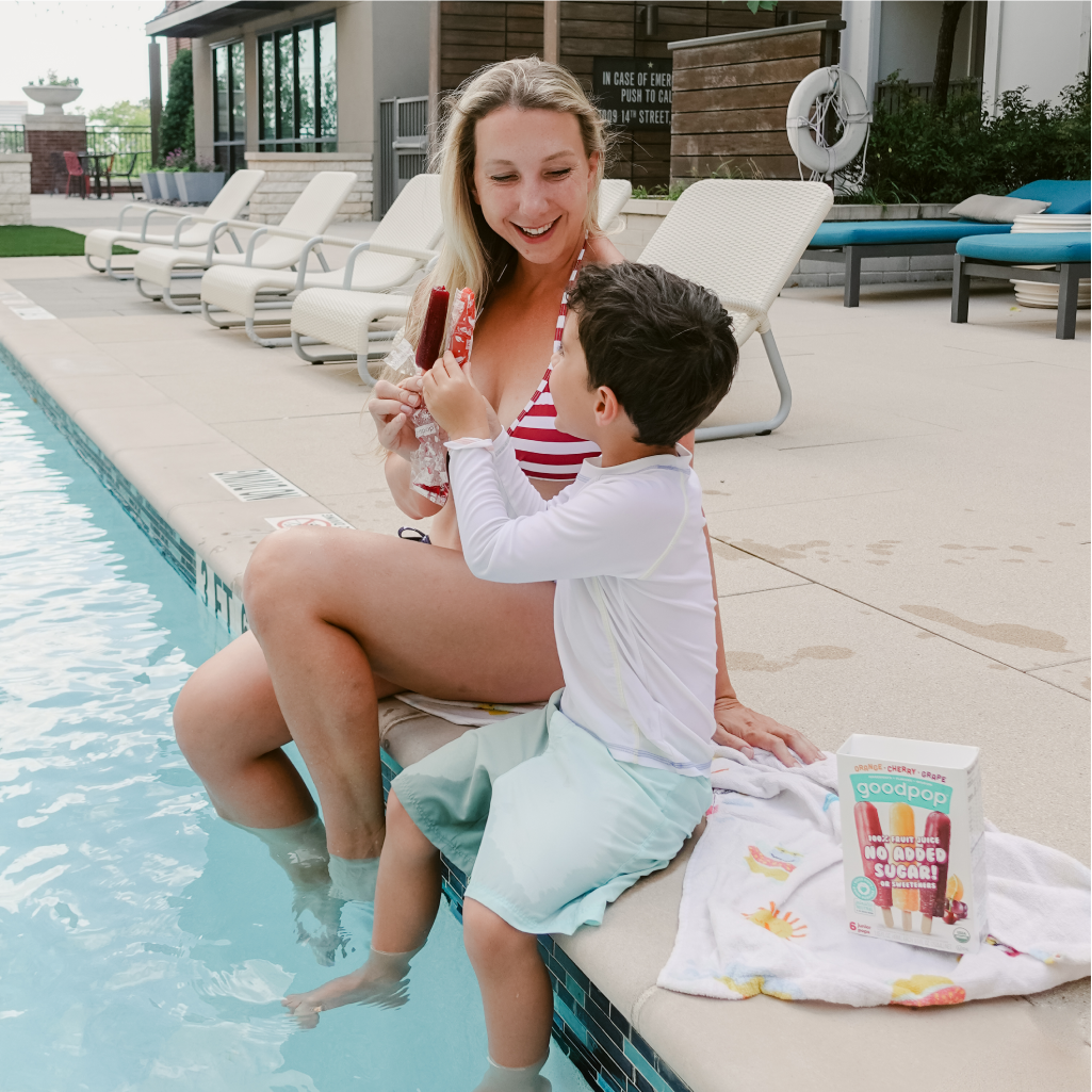 Mom and Boy sitting by pool eating GoodPop Junior Pops