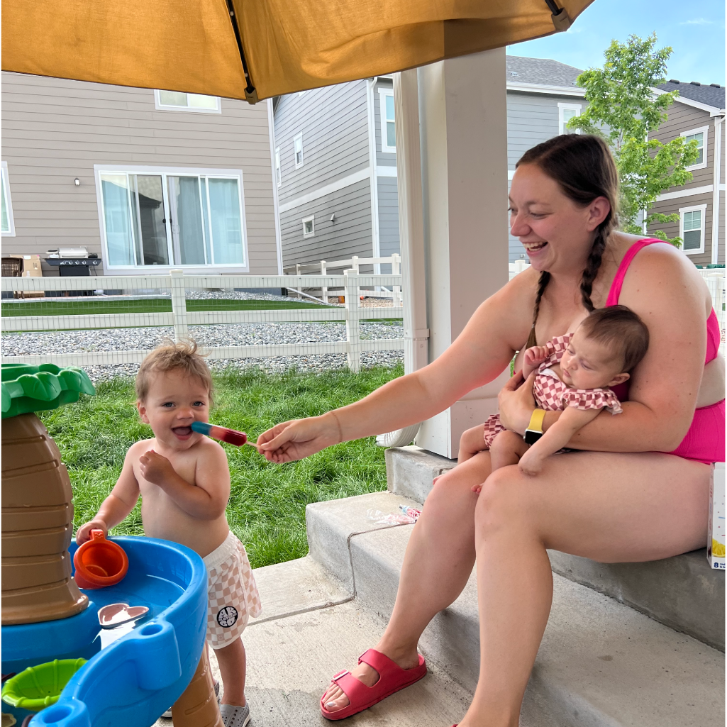 Mom and kids eating GoodPop while playing outside